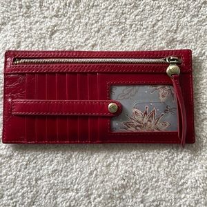 Slim wallet. 13 pockets, 1 clear slot. Zippered coin pouch and snap enclosure.